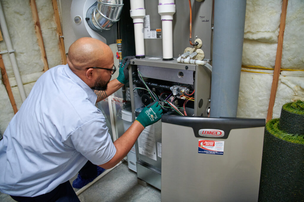 Technician installing a Lennox high-efficiency furnace in a Michigan basement.