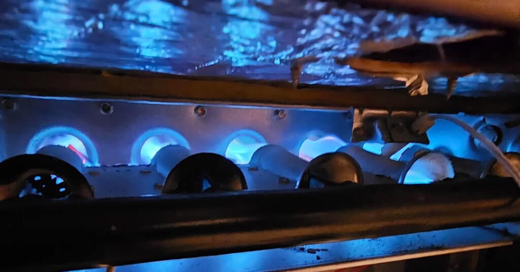 High-efficiency gas furnace burner with glowing blue flames for Michigan homes.