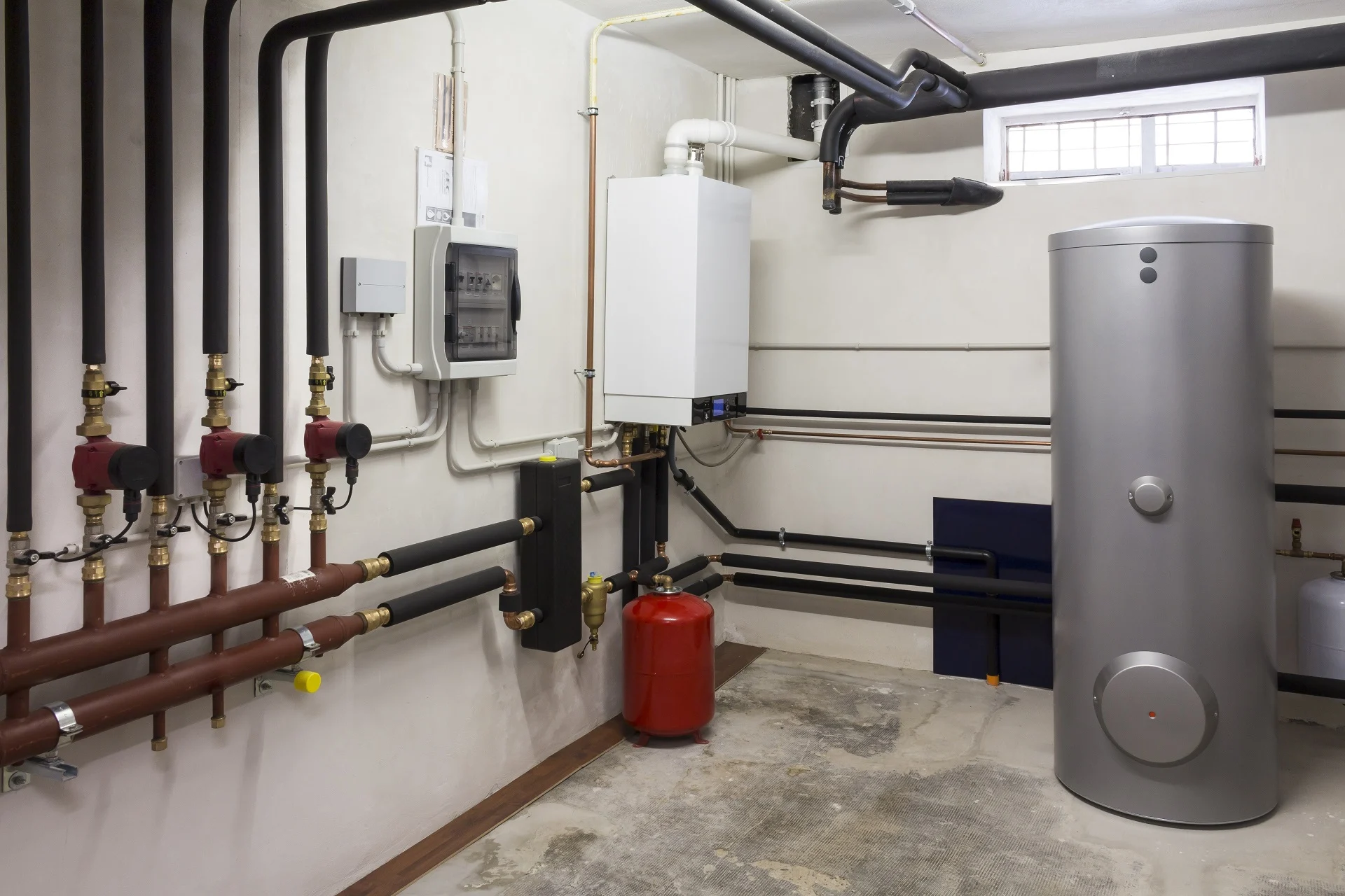 Modern water heater and plumbing system in a Michigan basement, illustrating efficient hot water solutions.