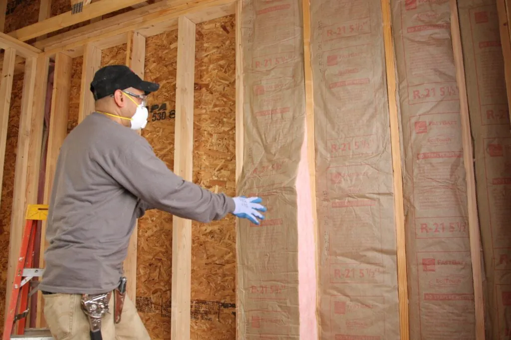 Michigan Smart Energy installer adding wall insulation in Southfield home, improving energy efficiency.